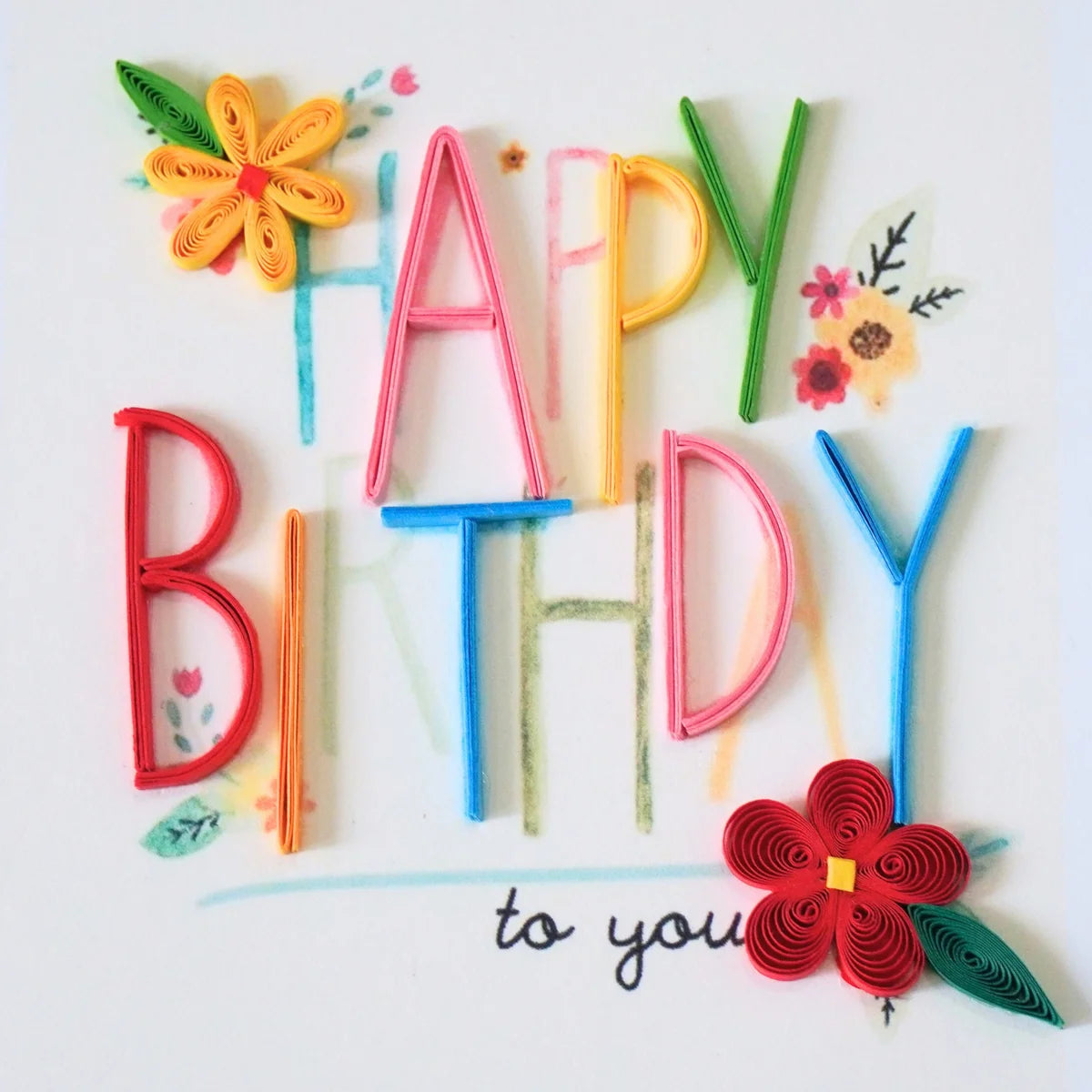 Detail of multicolored paper lettering and small red and yellow flowers