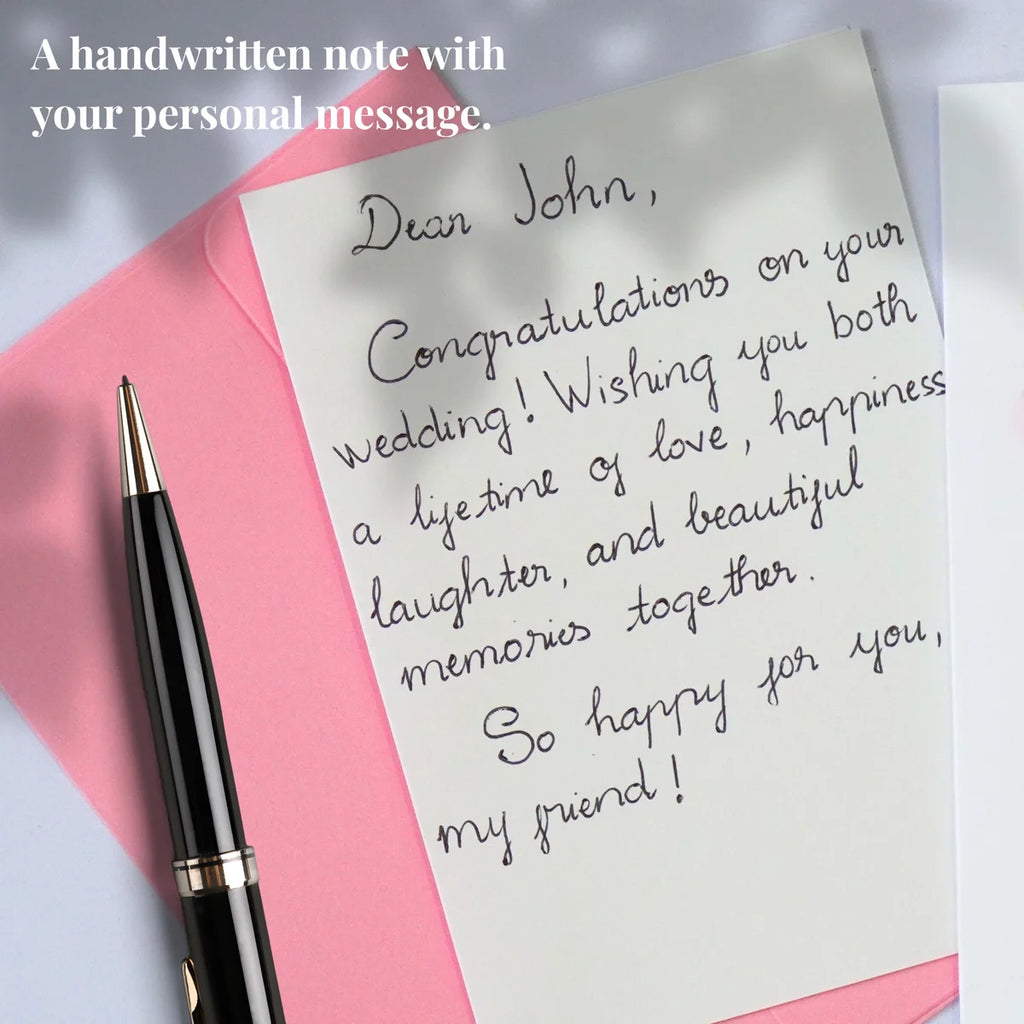 Example of a personal message handwritten on a card insert beside a pink envelope and pen
