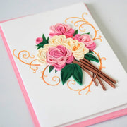 Angled view of pink and ivory rose bouquet quilled greeting card with green paper leaves