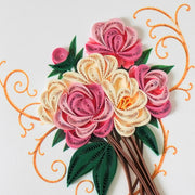 Detail of coiled pink and ivory paper roses with dark green leaves