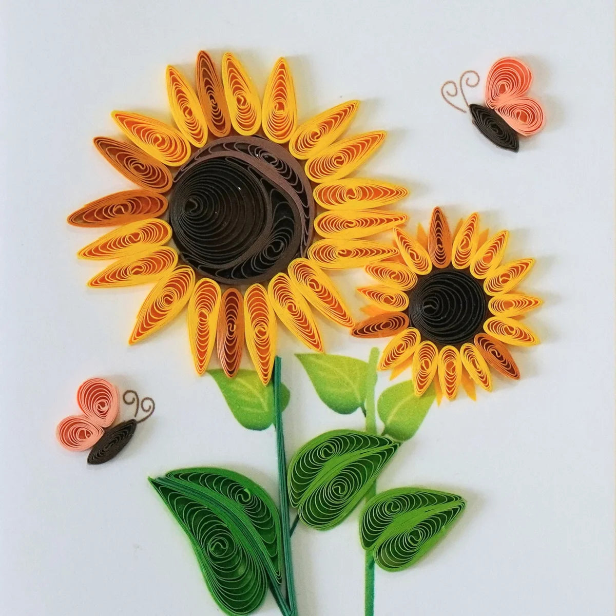 Detail of yellow and orange quilled sunflowers with butterflies and green leaves